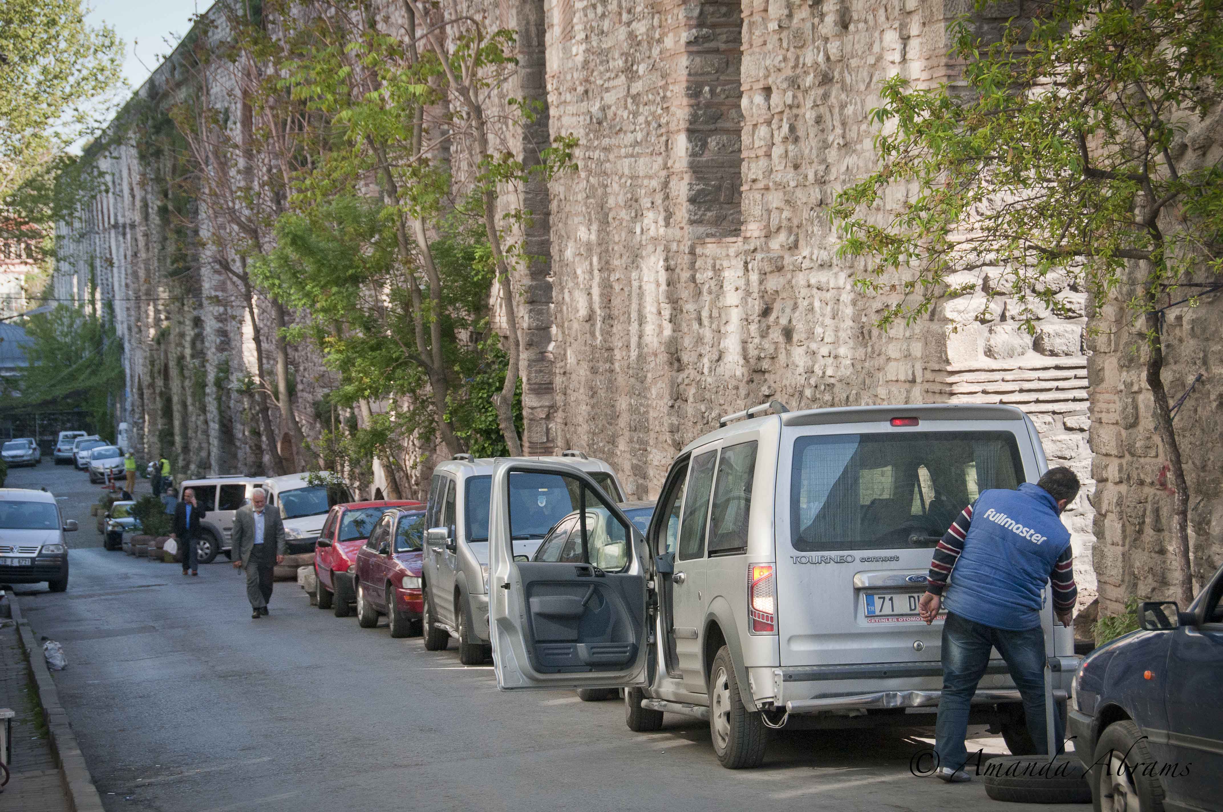 Cars parked against old city wall